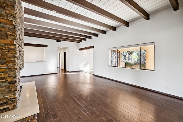 unfurnished living room featuring beam ceiling and dark hardwood / wood-style flooring