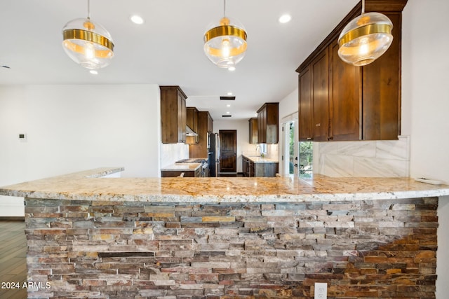 kitchen featuring kitchen peninsula, hardwood / wood-style floors, and hanging light fixtures