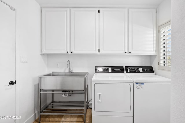 washroom with washer and clothes dryer and cabinets