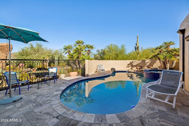 view of pool featuring a patio area and an in ground hot tub