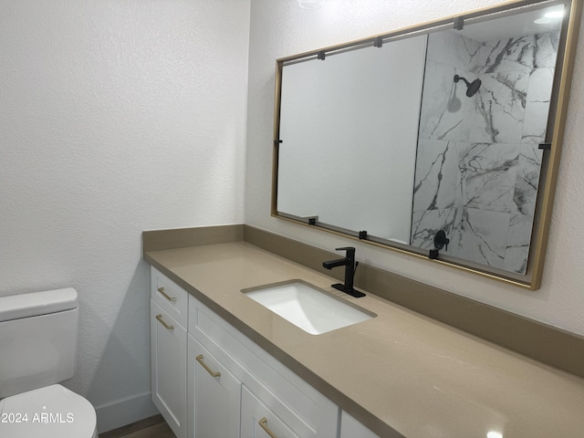 bathroom featuring vanity, a shower, and toilet