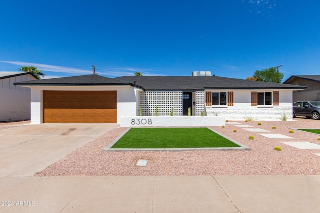 ranch-style house with a garage and a front lawn