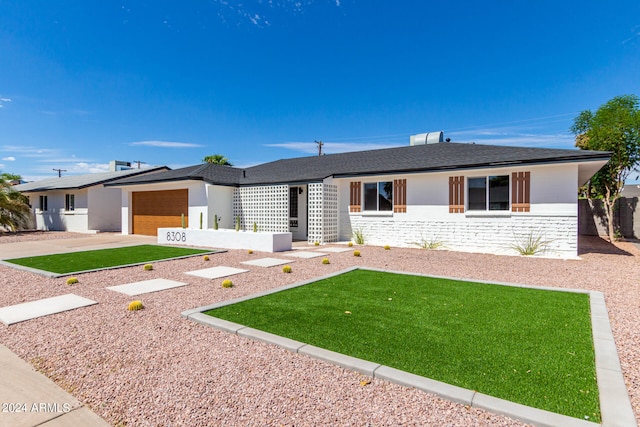 single story home featuring a front yard and a garage