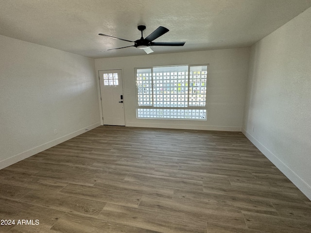 interior space with ceiling fan, a textured ceiling, and wood-type flooring