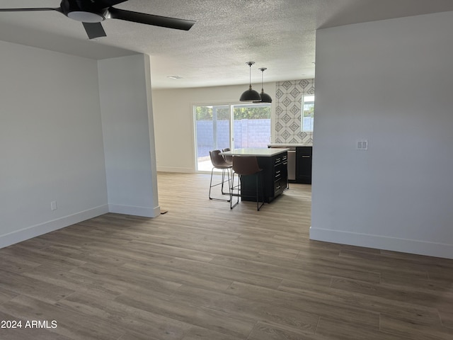 kitchen featuring a center island, light hardwood / wood-style floors, a kitchen bar, and decorative light fixtures