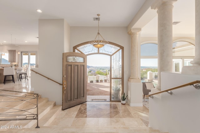 foyer with a healthy amount of sunlight and decorative columns