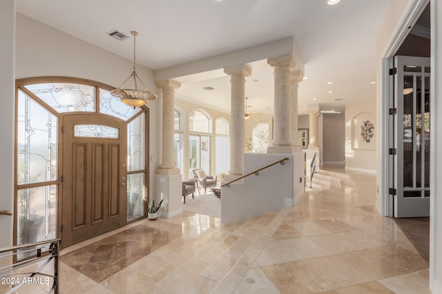 foyer with ornate columns and a healthy amount of sunlight