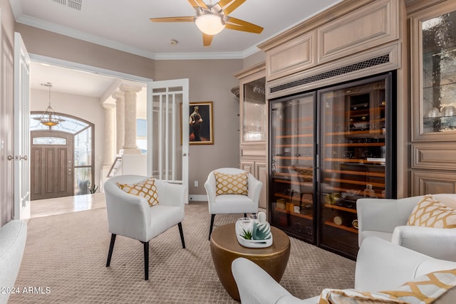 living room with wine cooler, crown molding, ceiling fan, and light colored carpet