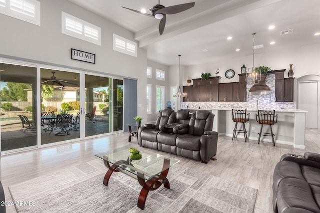 living room with light hardwood / wood-style flooring and ceiling fan with notable chandelier