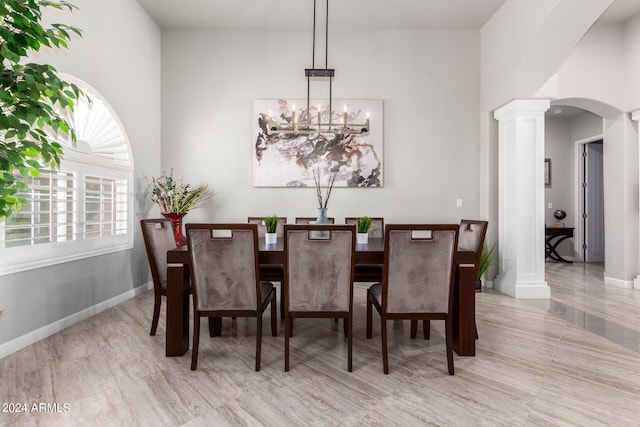 dining room with a chandelier and ornate columns