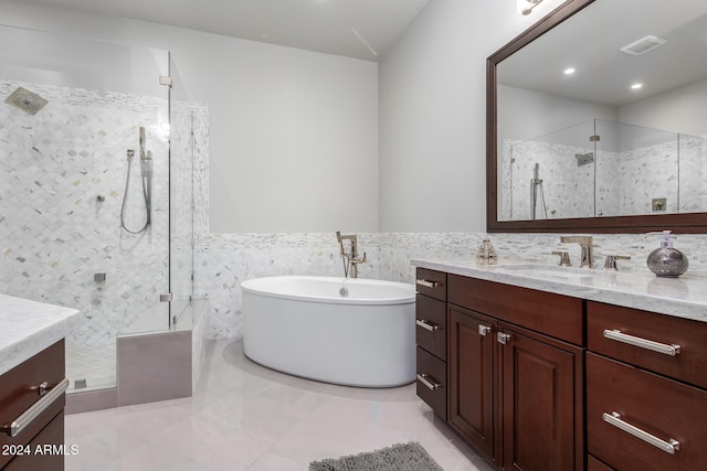 bathroom with vanity, separate shower and tub, tile patterned flooring, and tile walls