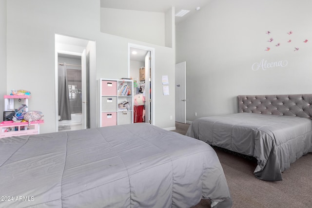 carpeted bedroom with high vaulted ceiling and connected bathroom