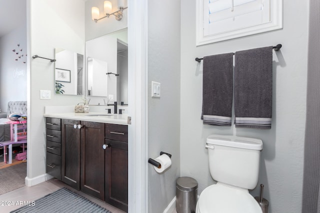 bathroom featuring toilet, vanity, and tile patterned floors