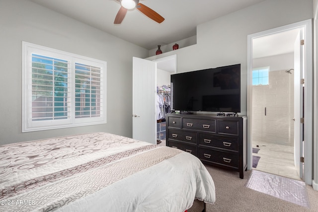 carpeted bedroom with a closet, ensuite bath, and ceiling fan