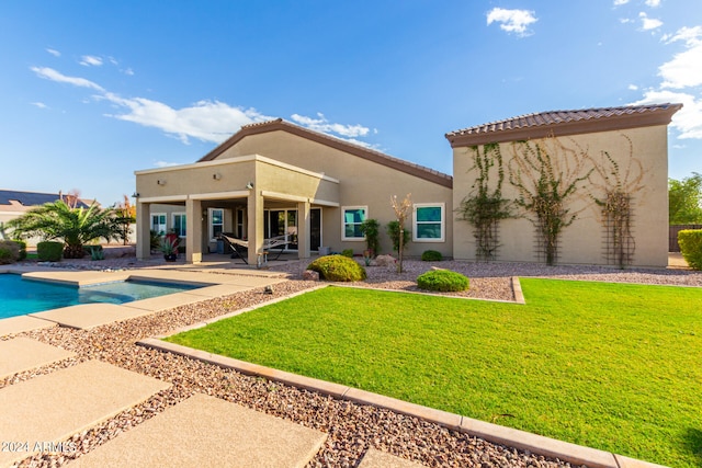 back of property with a patio area and a lawn