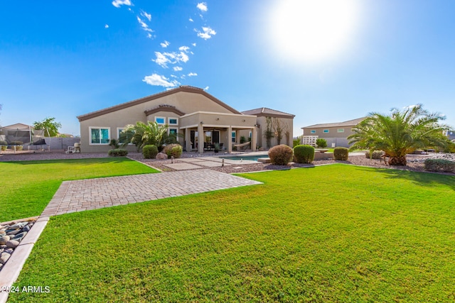 rear view of property with a patio and a lawn