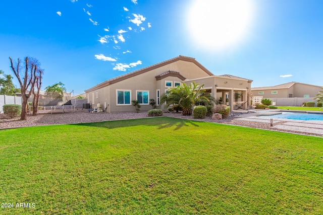 back of property featuring a fenced in pool, a yard, and a patio