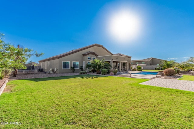 rear view of house featuring a yard and a patio area