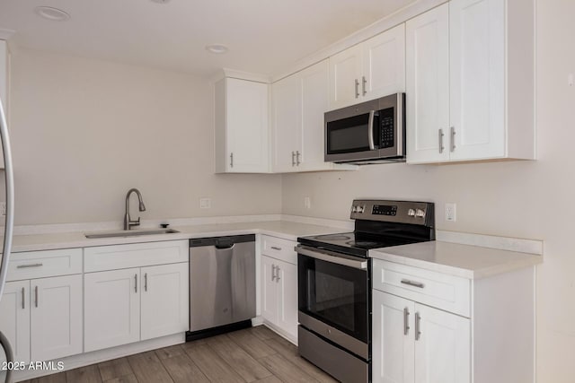 kitchen featuring stainless steel appliances, sink, and white cabinets