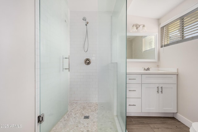 bathroom with hardwood / wood-style flooring, vanity, and a shower with door