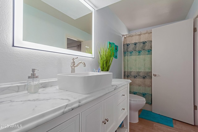 full bath with wood finish floors, a shower with shower curtain, vanity, and toilet