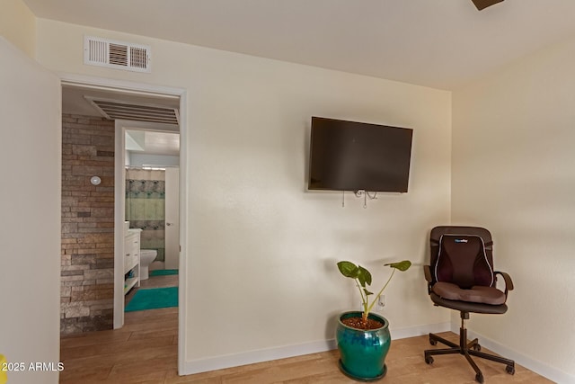 sitting room featuring baseboards, visible vents, and wood finished floors