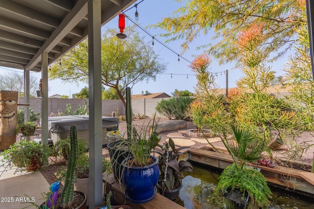 exterior space featuring fence and a hot tub