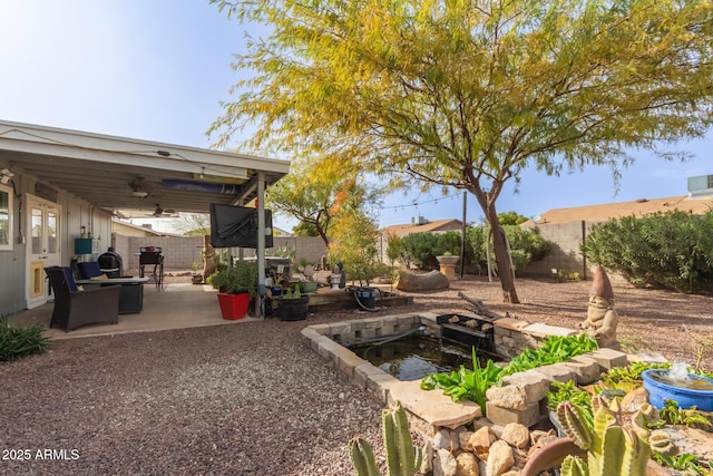 view of yard with a patio area, a fenced backyard, an outdoor fire pit, and a ceiling fan