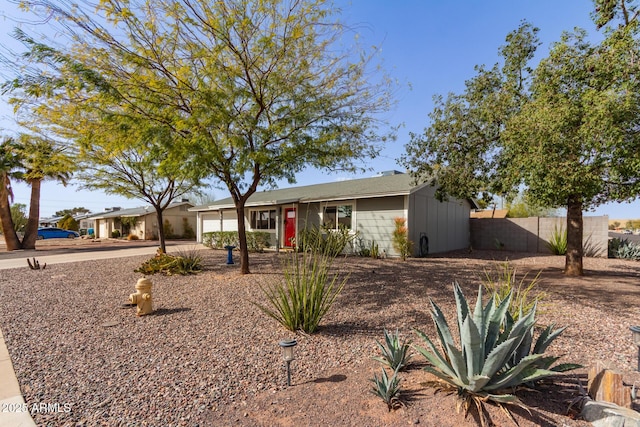 ranch-style home featuring driveway, an attached garage, and fence