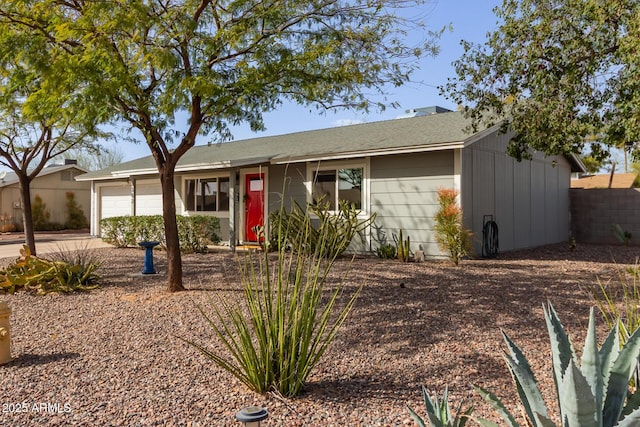 ranch-style home with driveway, an attached garage, and fence