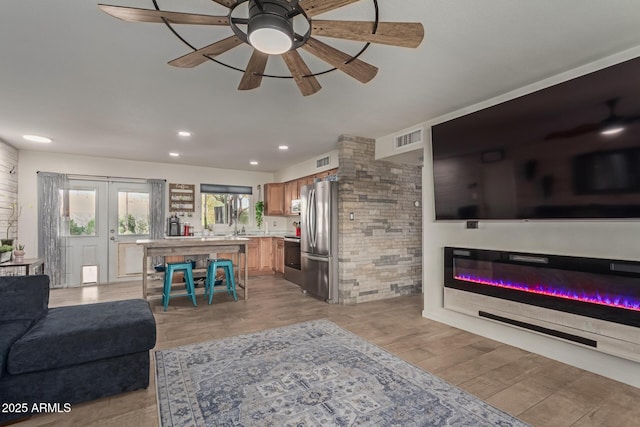 living area with french doors, recessed lighting, visible vents, and light wood-style floors