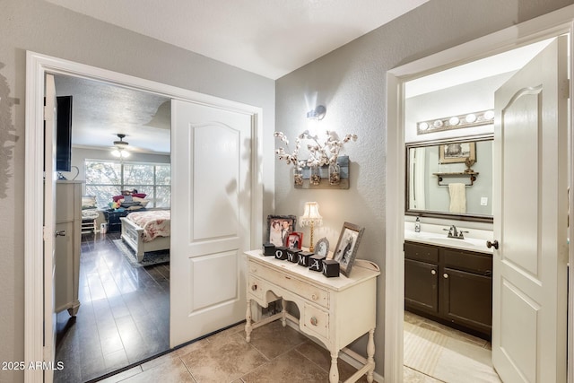 bathroom featuring ceiling fan, vanity, and a textured ceiling