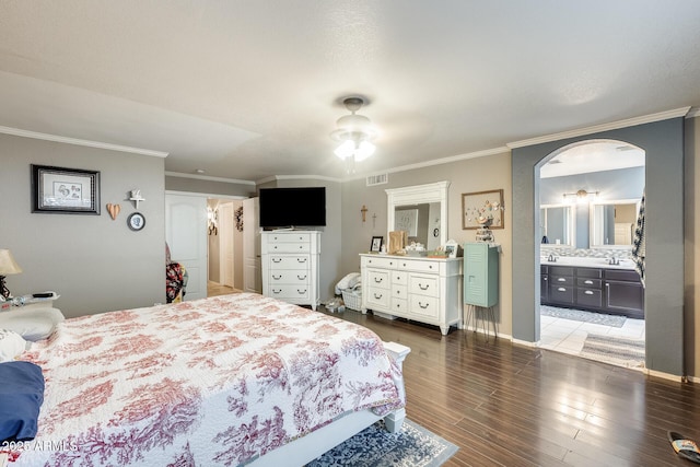 bedroom featuring crown molding, sink, connected bathroom, and hardwood / wood-style floors