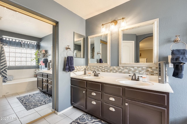 bathroom featuring a tub to relax in, tile patterned flooring, decorative backsplash, and vanity