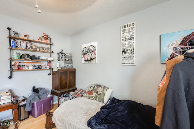 bedroom featuring wood-type flooring and a textured ceiling