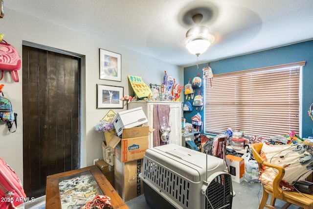 bedroom with ceiling fan and a textured ceiling