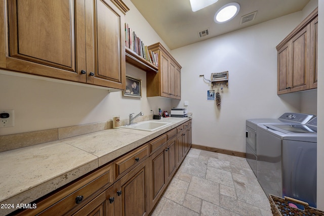 laundry area featuring cabinets, washer and dryer, and sink