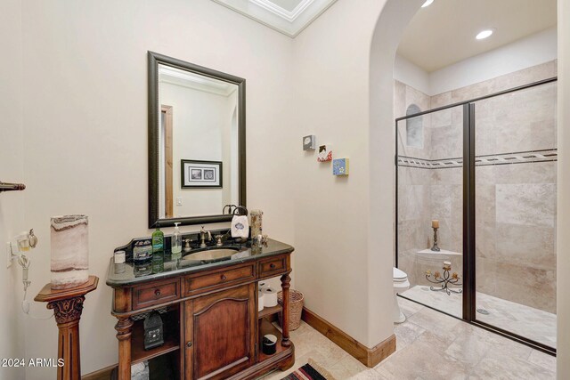 bathroom with toilet, vanity, an enclosed shower, and crown molding