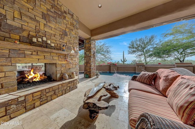 view of patio with pool water feature and an outdoor stone fireplace