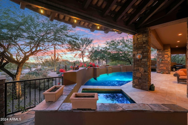 patio terrace at dusk featuring an in ground hot tub