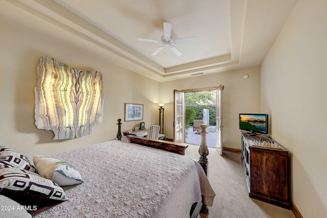 carpeted bedroom featuring access to outside, ceiling fan, and a raised ceiling