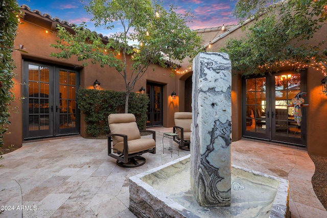 patio terrace at dusk featuring french doors