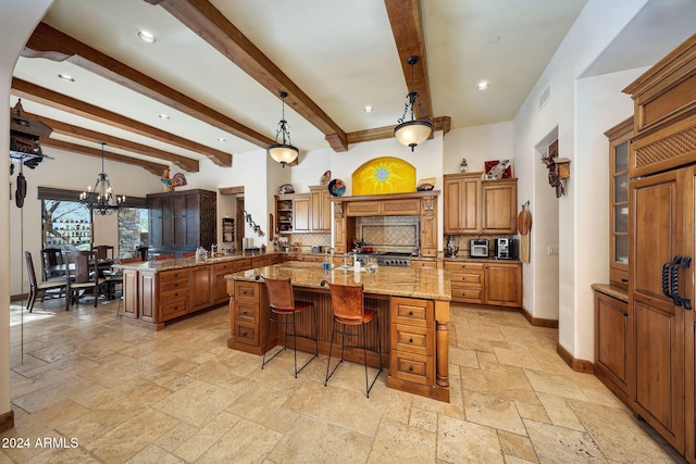 kitchen with a large island with sink, beamed ceiling, decorative light fixtures, and an inviting chandelier