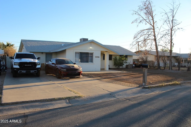 ranch-style home with driveway and a shingled roof