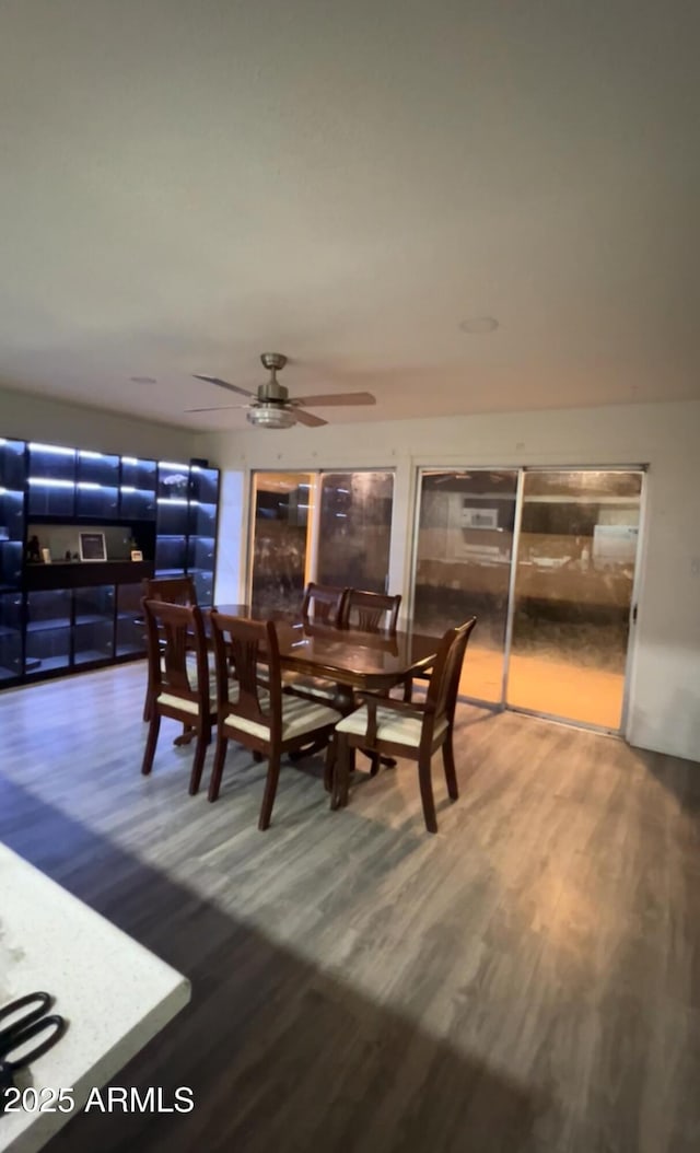 dining space with ceiling fan and wood finished floors