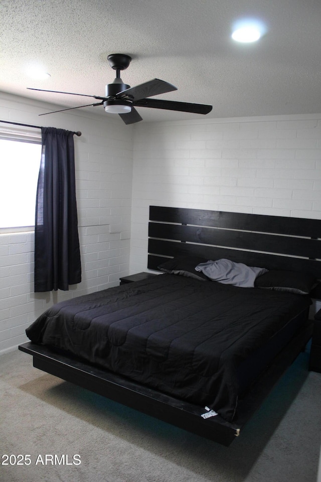 bedroom with a textured ceiling, carpet, and a ceiling fan