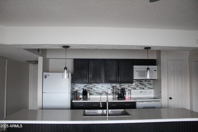 kitchen featuring tasteful backsplash, white appliances, light countertops, and a sink