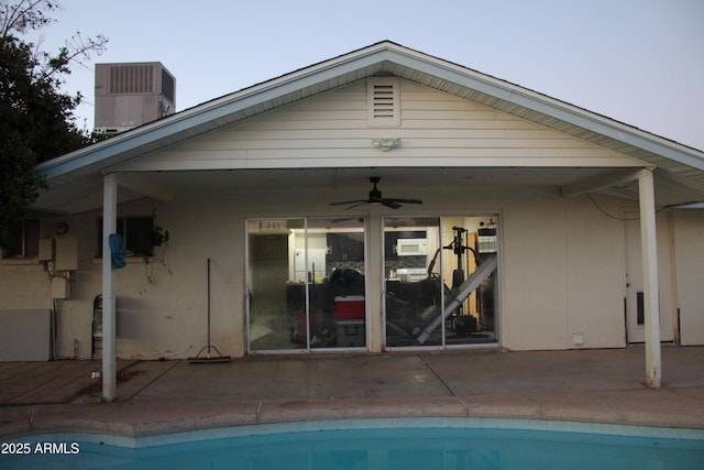 rear view of property featuring central AC unit, a patio area, a ceiling fan, and an outdoor pool