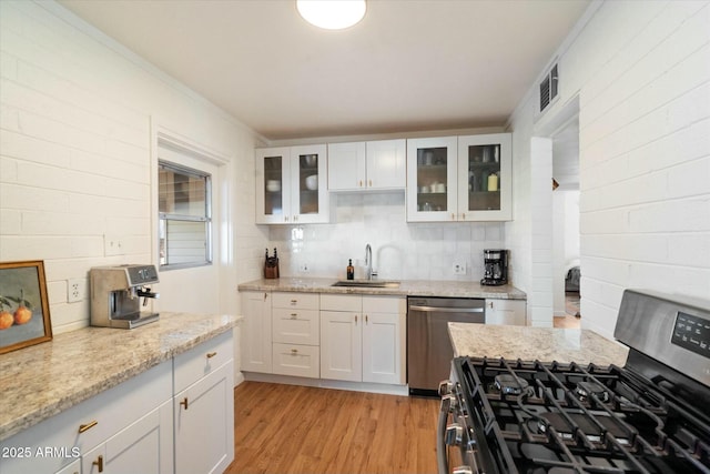 kitchen featuring sink, light wood-type flooring, white cabinets, and appliances with stainless steel finishes