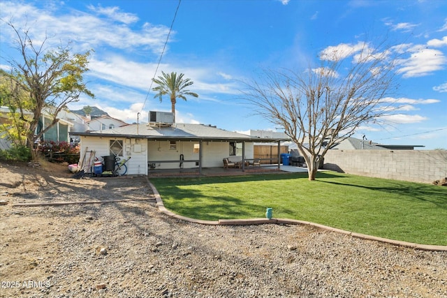 rear view of property featuring central AC unit, a yard, and a patio